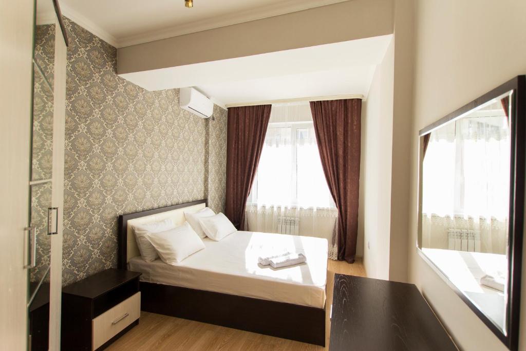 Habitación pequeña con cama y ventana en Residential complex Central 271, en Almaty