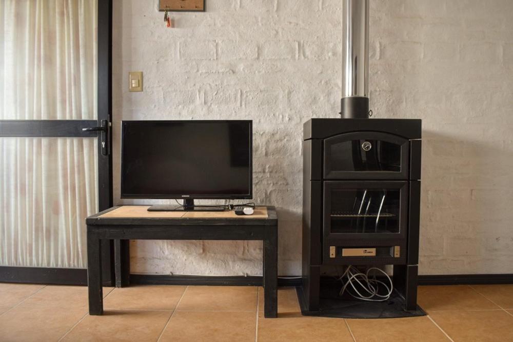 a tv sitting on a table with a desk with a television at Atlantida casi en la playa in Atlántida