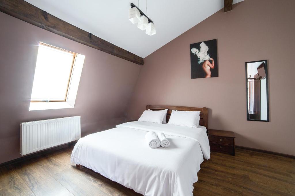 リヴィウにあるAparthotel Na Mytniyのベッドルーム1室(白いベッド2台、窓付)