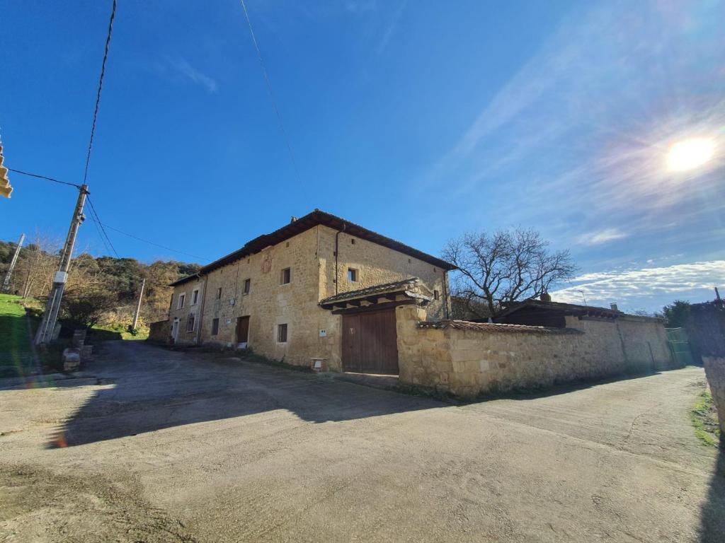 un viejo edificio de ladrillo en un camino de tierra en CASA RURAL PALACIO LOS LABREQUINES, en Villacomparada de Rueda