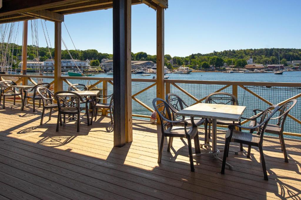 a dining room table with chairs and umbrellas at Fisherman's Wharf Inn in Boothbay Harbor