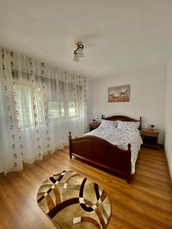 a bedroom with a bed and a wooden floor at Apartament Sunshine in Orşova