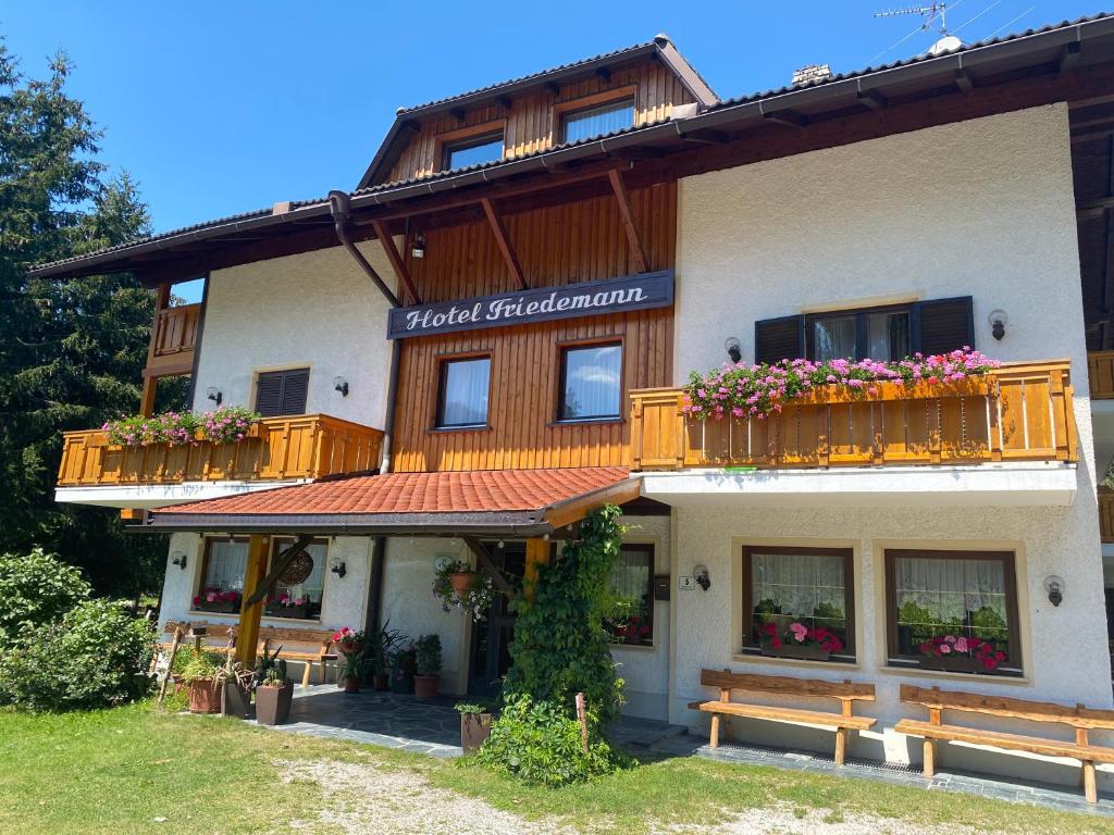 a building with benches in front of it at Hotel Friedemann in Rasùn di Sotto