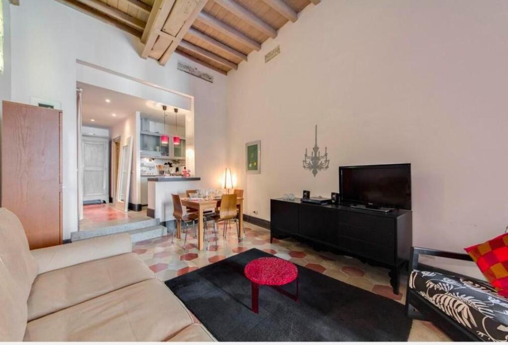 a living room with a couch and a tv and a table at 5 scole apartments in Rome