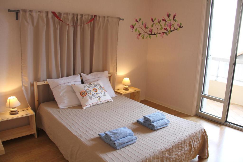 una camera da letto con un letto e asciugamani di Au Lion d'Or a Le Puy en Velay