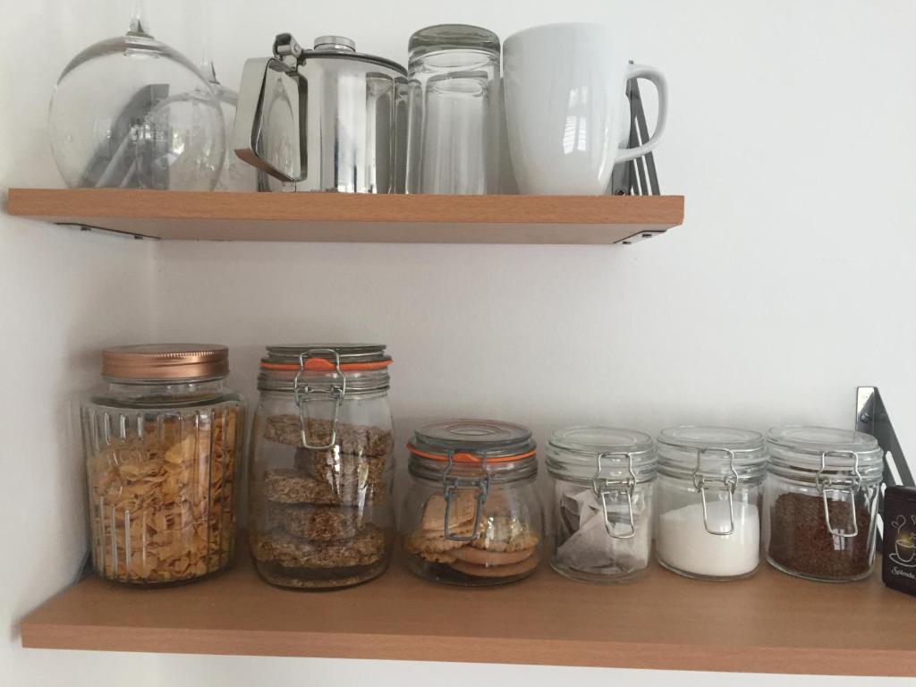 a shelf with jars of food on it at Basingstoke En Suite Room in Garden Annex in Basingstoke