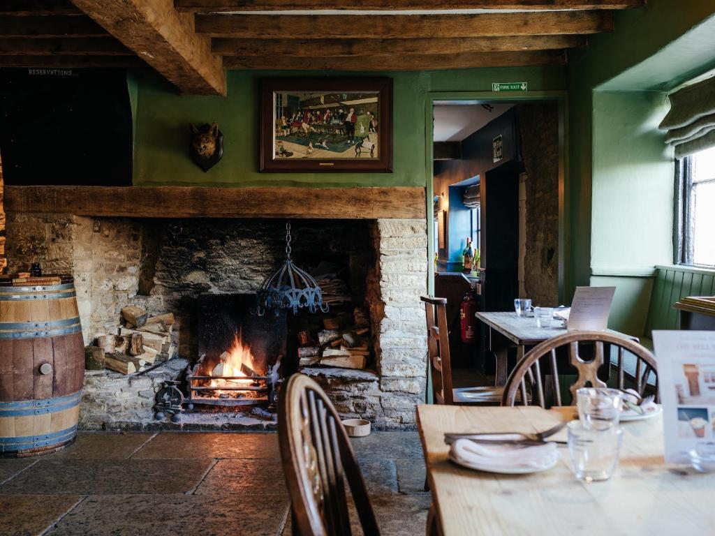 a fireplace in a dining room with a table and a fire place at The Bell Inn in Lechlade