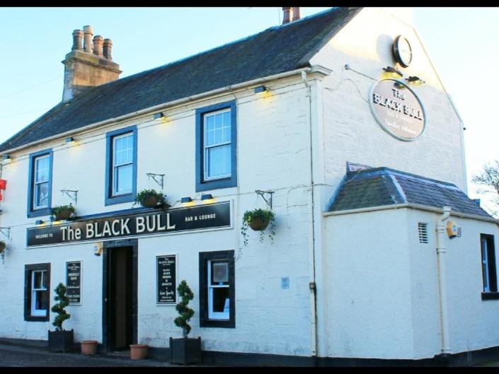 The Blackbull Inn Polmont في Polmont: مبنى أبيض عليه علامة ثور أسود