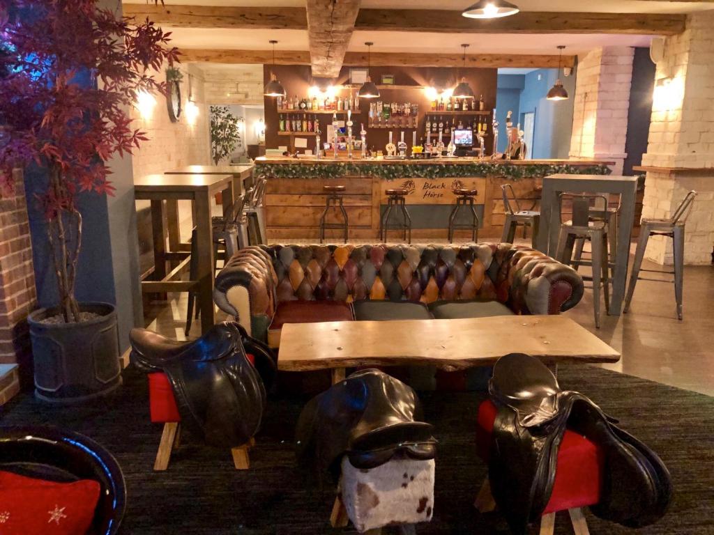 a living room with a couch and a bar at Black Horse in Peterborough