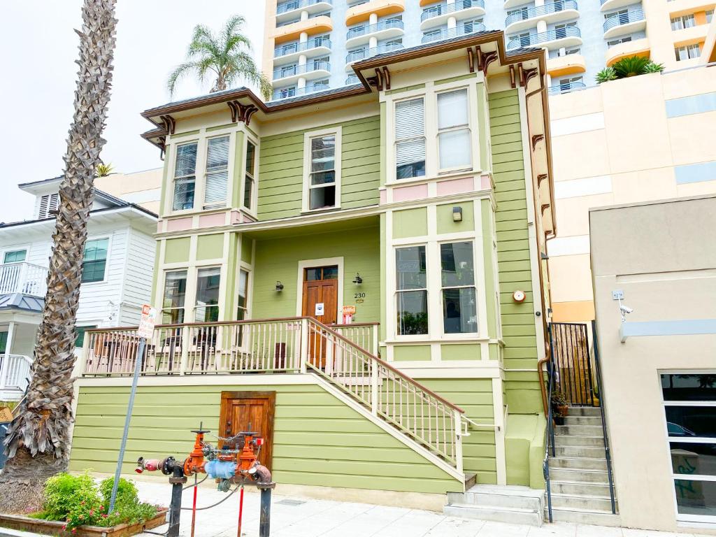 a green house with a palm tree at ITH Adventure Hostel San Diego in San Diego