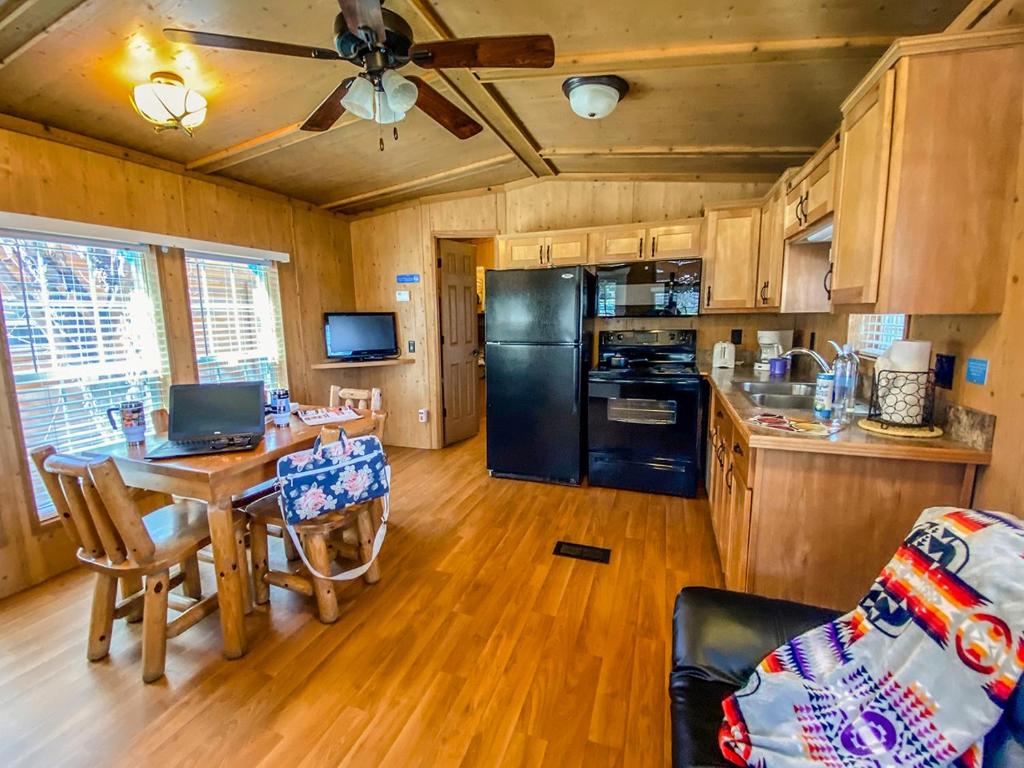 a kitchen with a table and a black refrigerator at Healing Waters Resort and Spa in Pagosa Springs