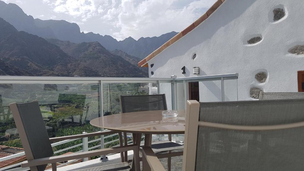 a balcony with a table and a view of mountains at Apartamento Casa Bibiana 1 in Hermigua