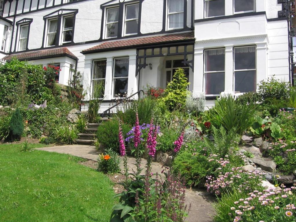 a garden in front of a house with flowers at Bryn Derwen Guest House in Conwy