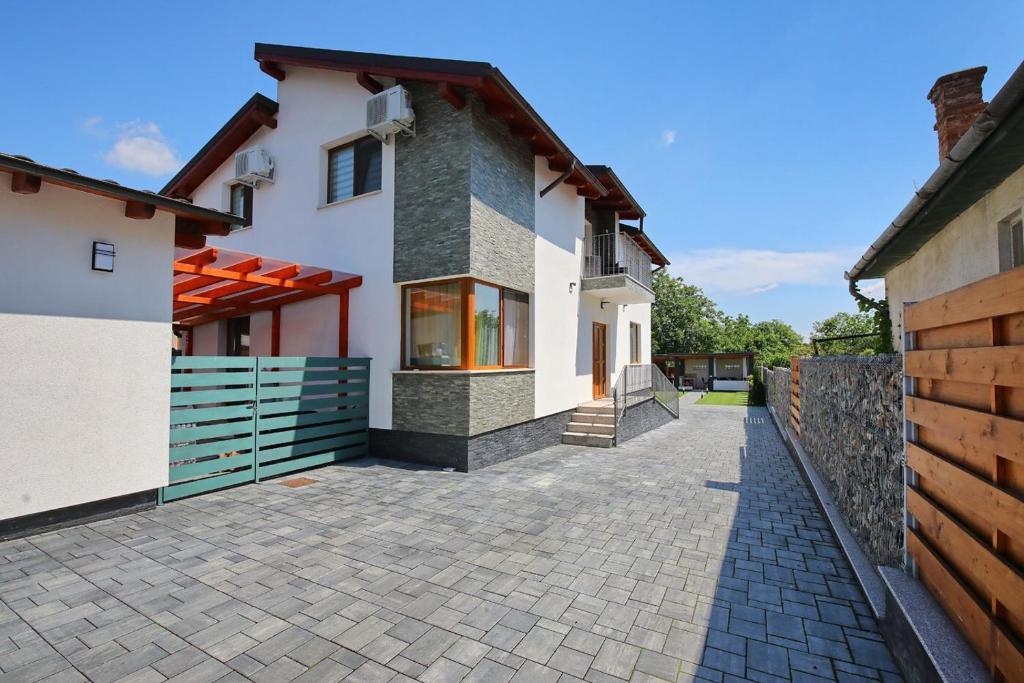 a house with a fence and a brick driveway at Casa Sorriso in Turda