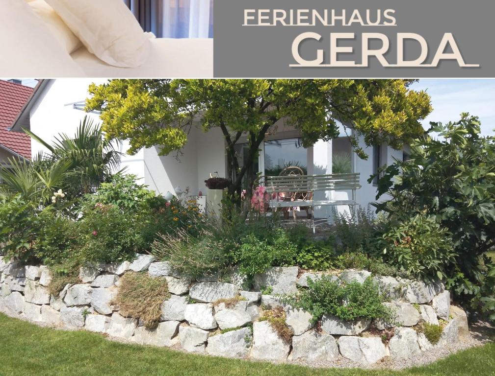un jardín frente a una casa con una pared de piedra. en Ferienhaus Gerda, en Friesenheim
