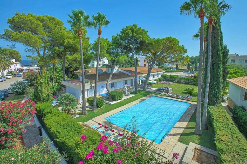 una vista aérea de una piscina con palmeras en Beach Villa Can Ros, en Puerto Pollensa
