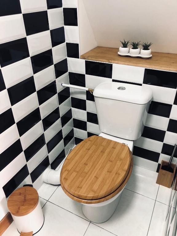 a bathroom with a toilet with a wooden seat at Gîte avec jardin à 1,5 km des plages du débarquement in Tracy-sur-Mer