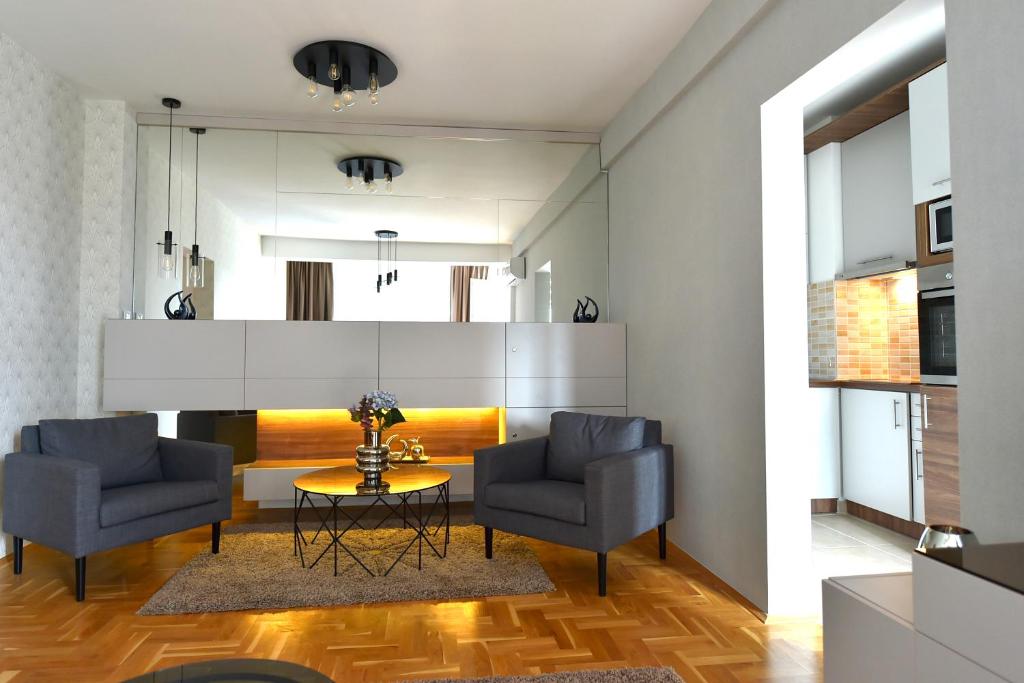 a living room with two chairs and a table at Sky lux apartman in Gornji Milanovac