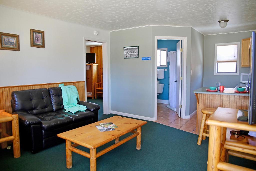 a living room with a black leather couch and a table at Healing Waters Resort and Spa in Pagosa Springs