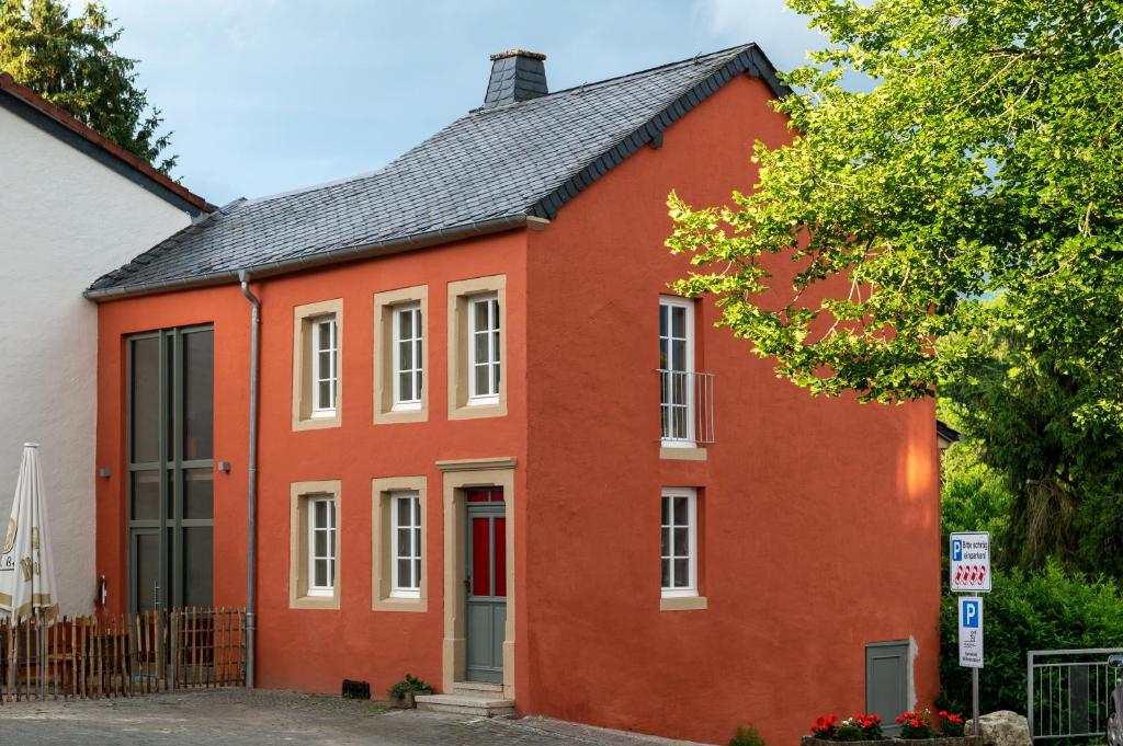 a red house with a black roof at Nengshof Ferienhaus Glockenblume in Wißmannsdorf
