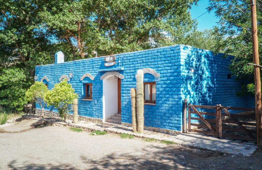 a blue house in the middle of the forest at Azul Humahuaca Hostal in Humahuaca