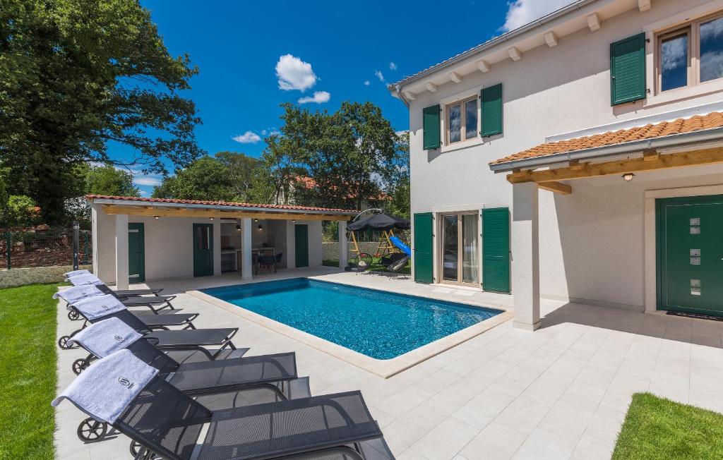 a house with a swimming pool and chairs at Martinela Villas Istria - Villa Franko in Rojnići