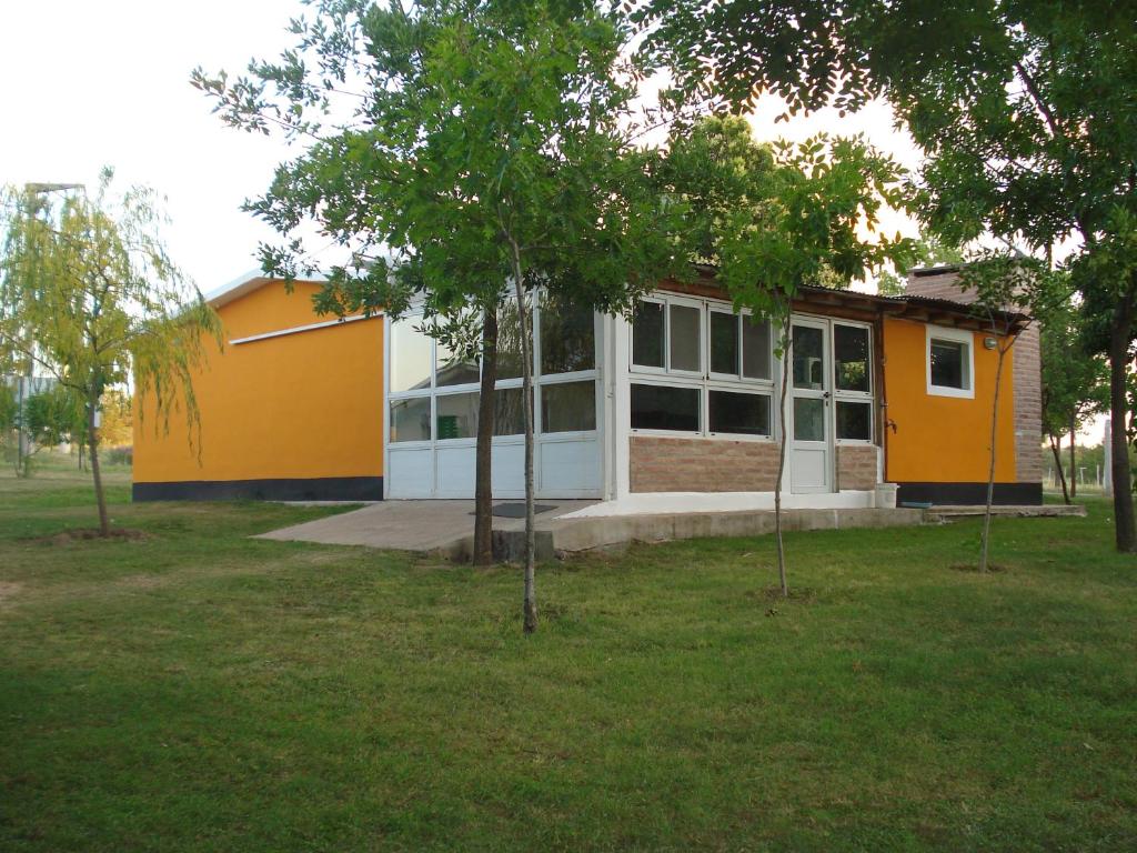 a yellow and white building with trees in a field at Finca La Virreinita in Panaholma