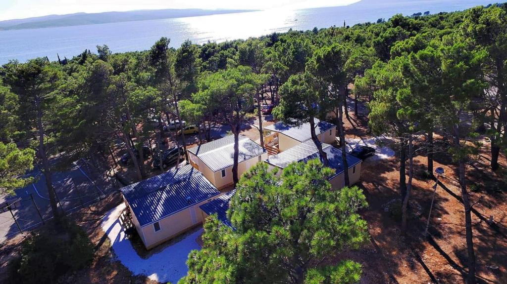 une vue de tête sur une maison sur une colline arborée dans l'établissement Mobile Homes Sara - Camping Baško Polje , Adriatic , Dalmatia, à Baška Voda