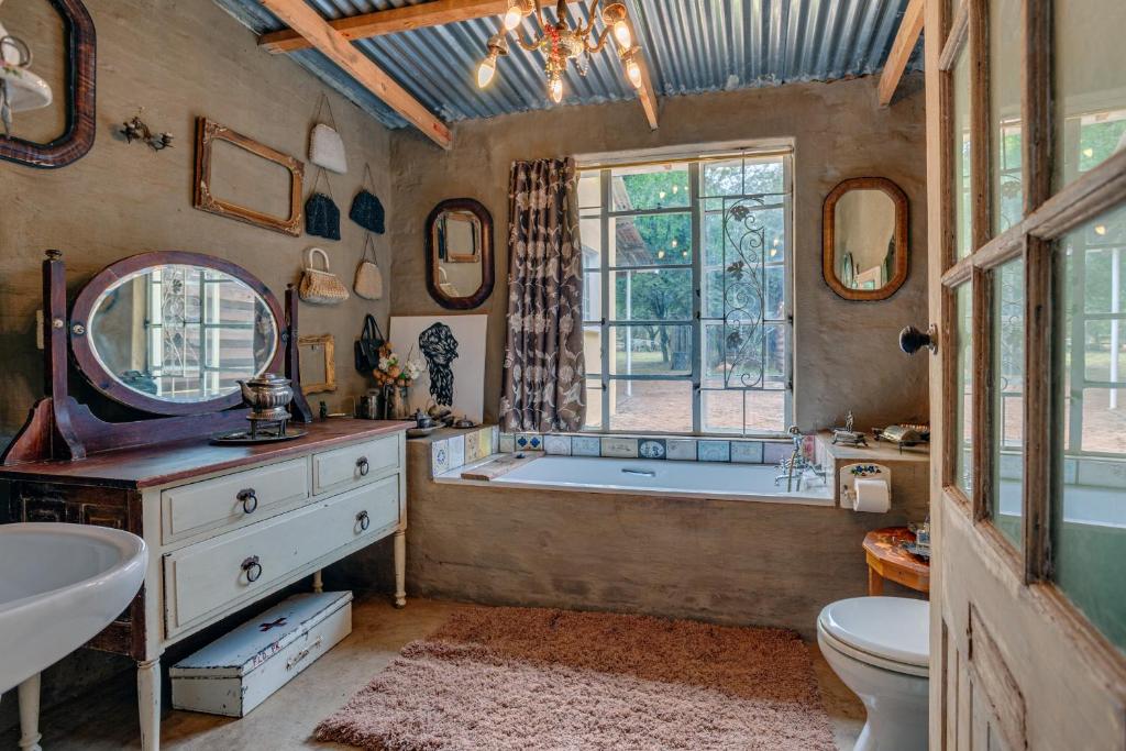 a bathroom with a tub and a toilet and a sink at THE LAZY LAPA in Magaliesburg