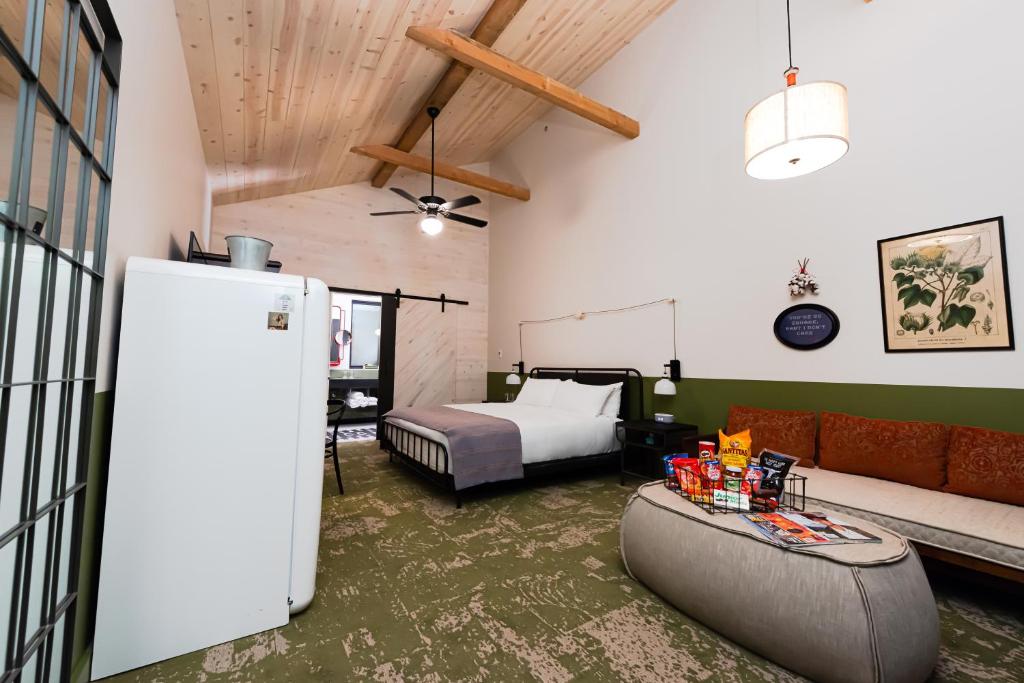 a room with a bed and a couch and a refrigerator at Cotton Court Hotel, by Valencia Hotel Collection in Lubbock