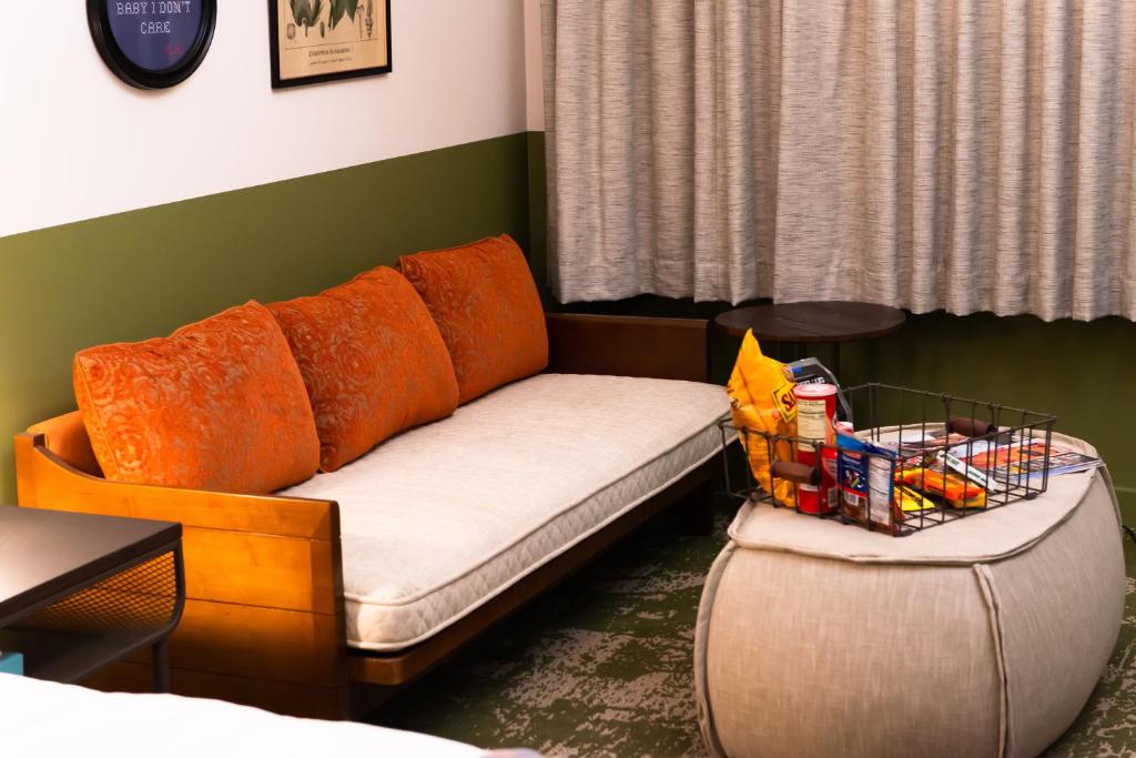 a couch and a stool in a living room at Cotton Court Hotel, by Valencia Hotel Collection in Lubbock