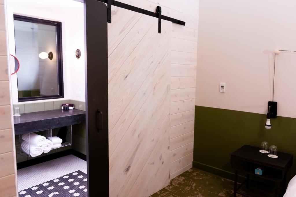 a bathroom with a sliding door with a sink and a mirror at Cotton Court Hotel, by Valencia Hotel Collection in Lubbock