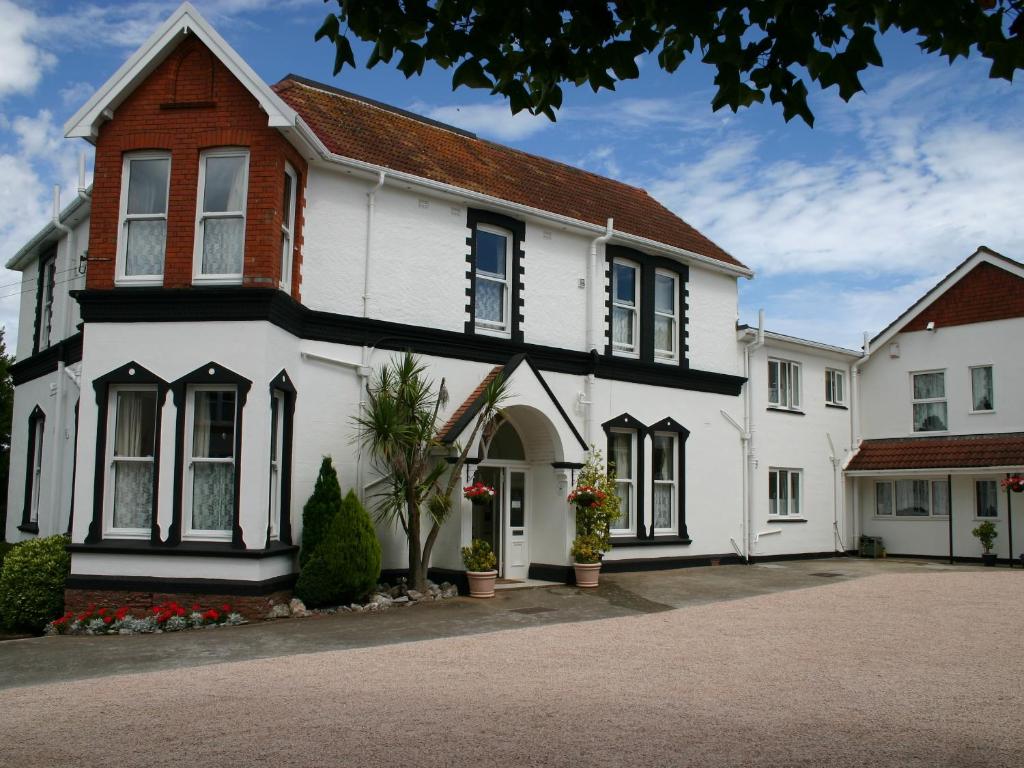 uma casa branca com enfeites a preto e branco em Broadshade Holiday Apartments em Paignton
