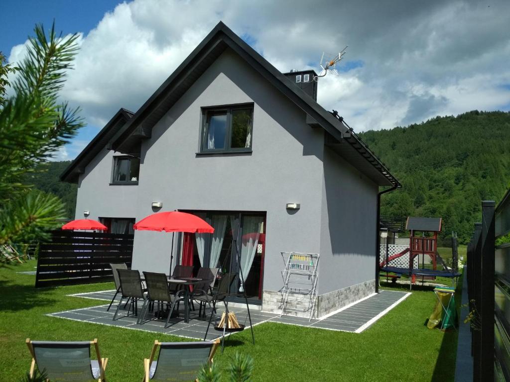 a house with a patio with a table and chairs at Słoneczne Domki in Krościenko