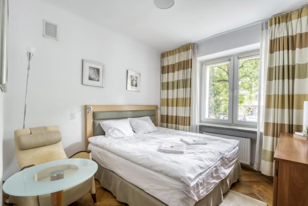 una camera con letto, tavolo e finestra di 404 Rooms Obrzezna Mokotow a Varsavia