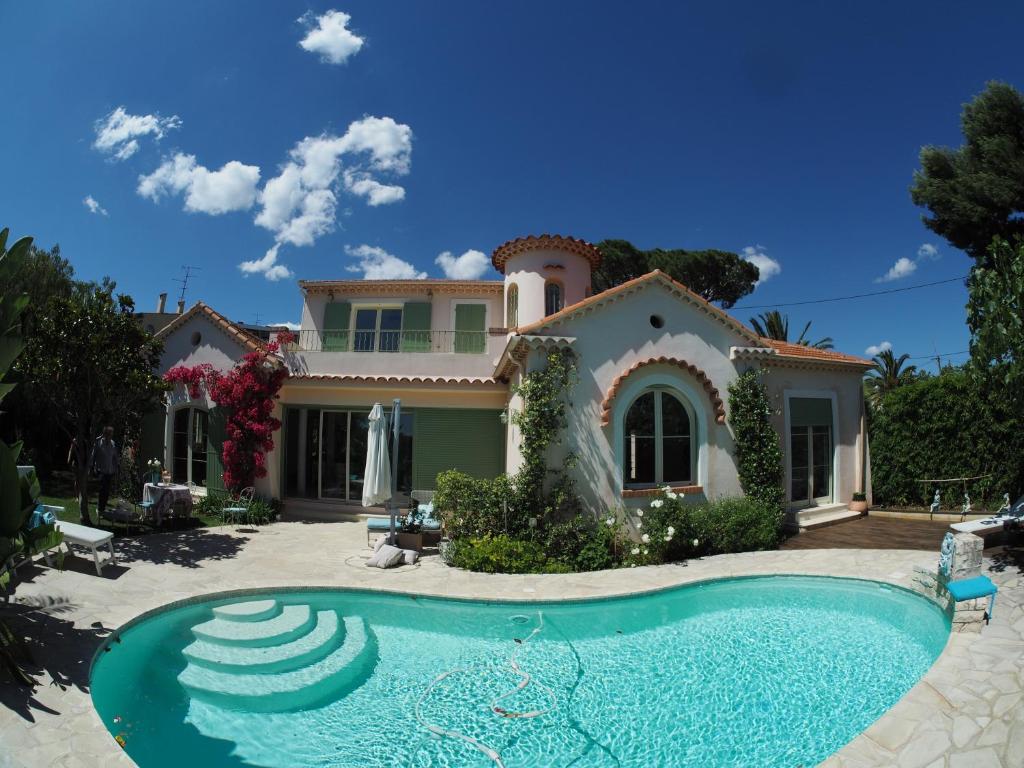 a house with a swimming pool in front of it at Blue Dream Cannes Guest House in Cannes