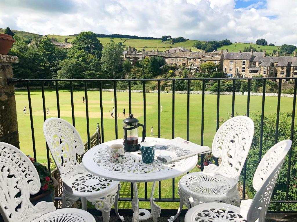 a white table and chairs with a view of a field at Spring Bank Cottage in Highpeak Junction