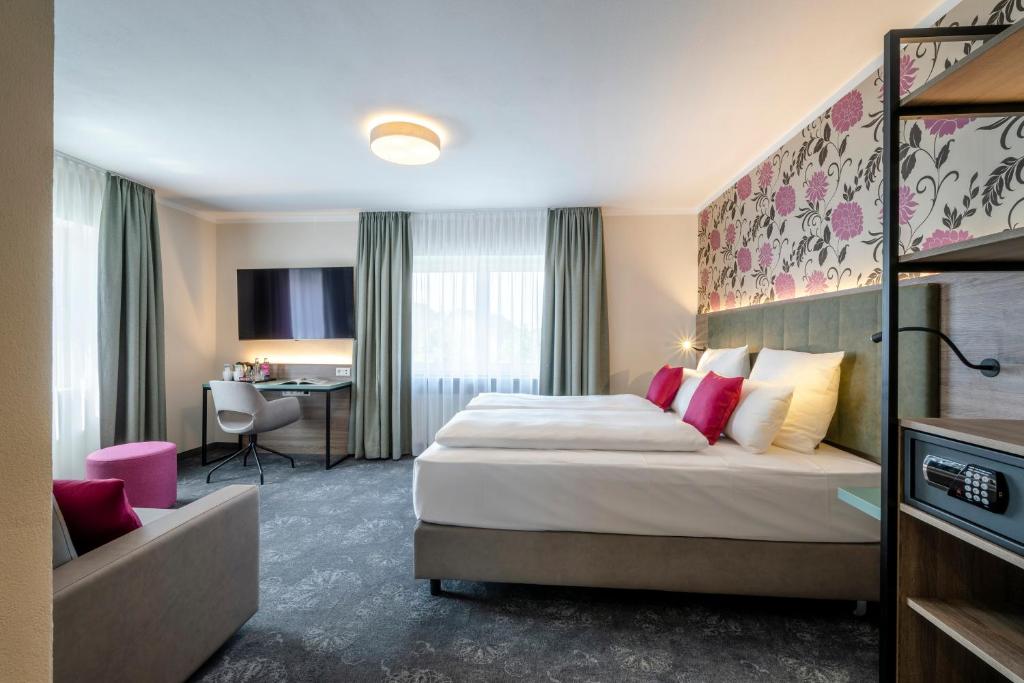 een hotelkamer met een bed en een bureau bij Boutique Hotel Erb München Parsdorf in Parsdorf