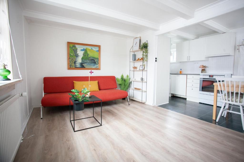 a living room with a red couch and a table at Two Bedroom Vacation Home in the Center of Tórshavn in Tórshavn
