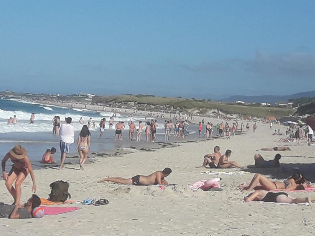 a group of people laying on the beach at Apartamentos Turísticos Rosa in Ribadeo
