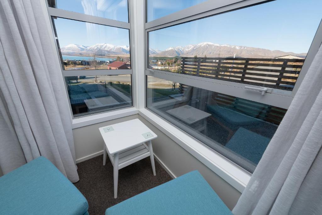 a room with a window with a view of the mountains at Cairnsmore Apartment in Lake Tekapo