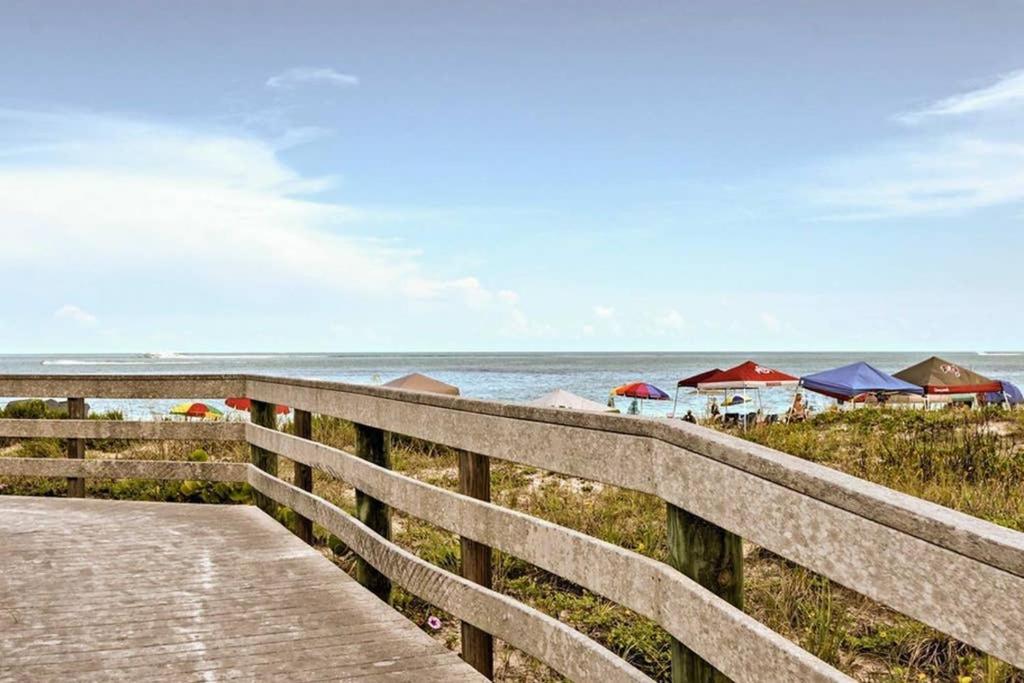 eine hölzerne Promenade, die zu einem Strand mit Häusern führt in der Unterkunft Rita's Sand Key Gem in Clearwater Beach