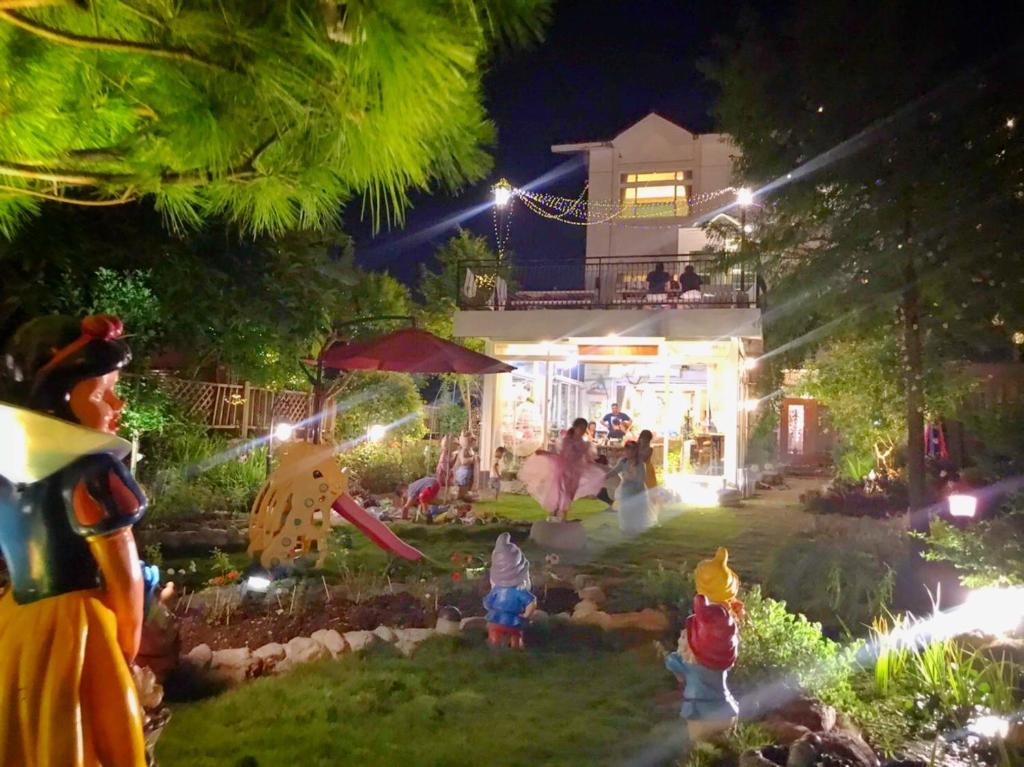 a group of people in front of a house at night at 花蓮 達芙妮花園民宿 in Ji'an