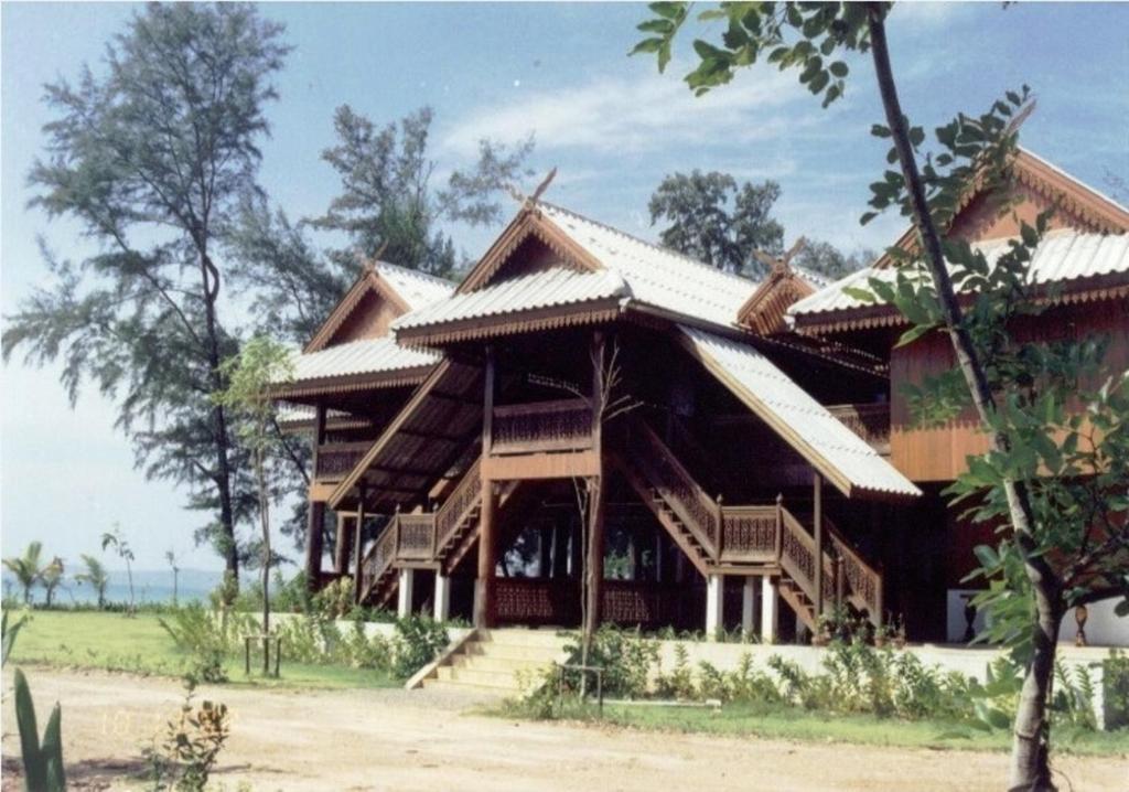 a large wooden house with stairs in front of it at Ruen Thai Rim Haad in Klaeng