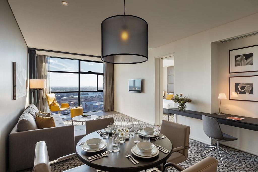 comedor y sala de estar con mesa y sillas en Fraser Suites Sydney, en Sídney