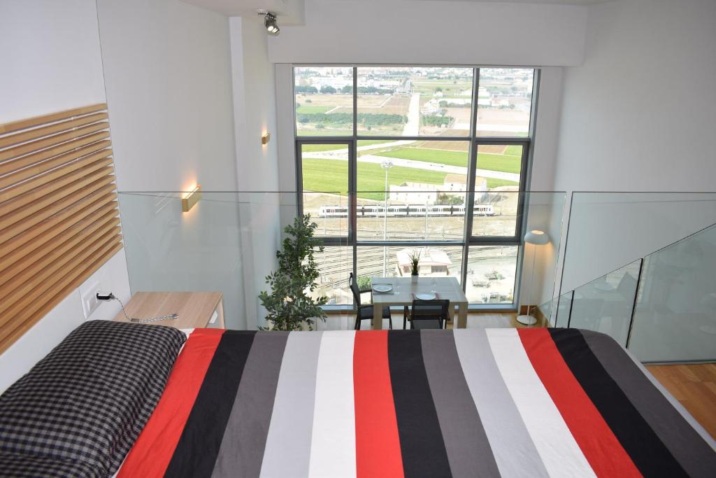 1 dormitorio con cama, mesa y ventana en Duplex LOFT Apartamento con Parking GRATIS en Valencia