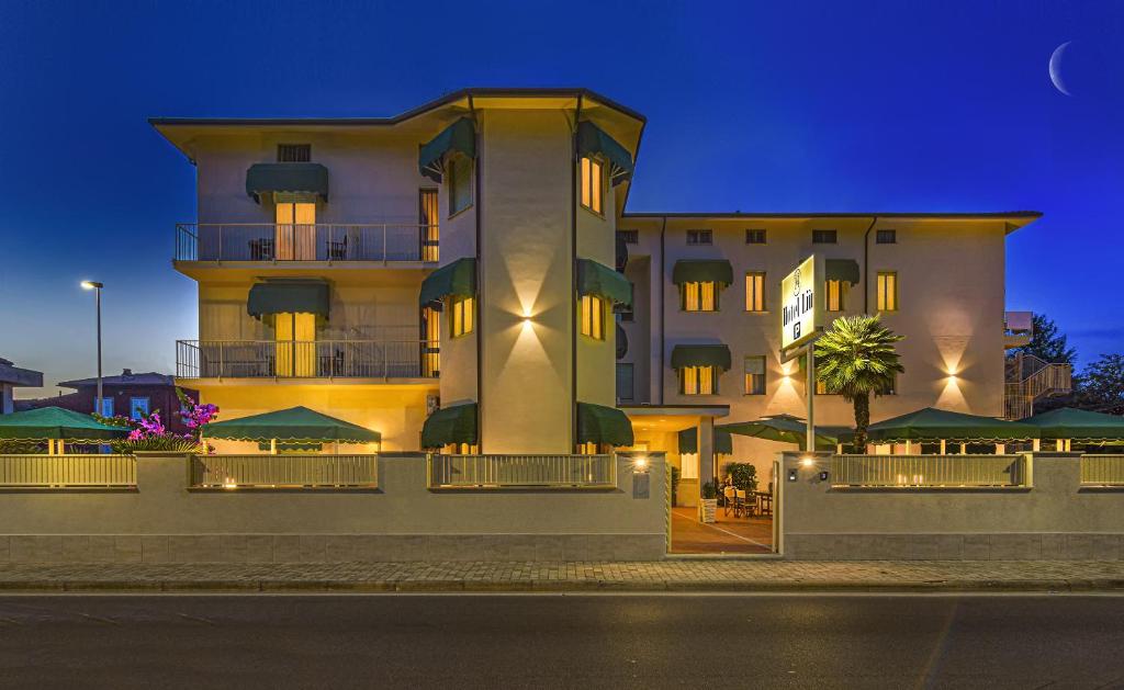 un gran edificio con sombrillas delante en Hotel Liu, en Lido di Camaiore