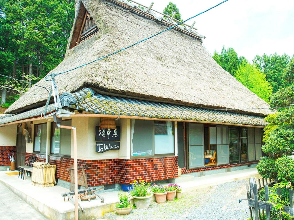 un bâtiment au toit de chaume avec des plantes en face dans l'établissement Kyoto - House / Vacation STAY 14527, à Kyoto