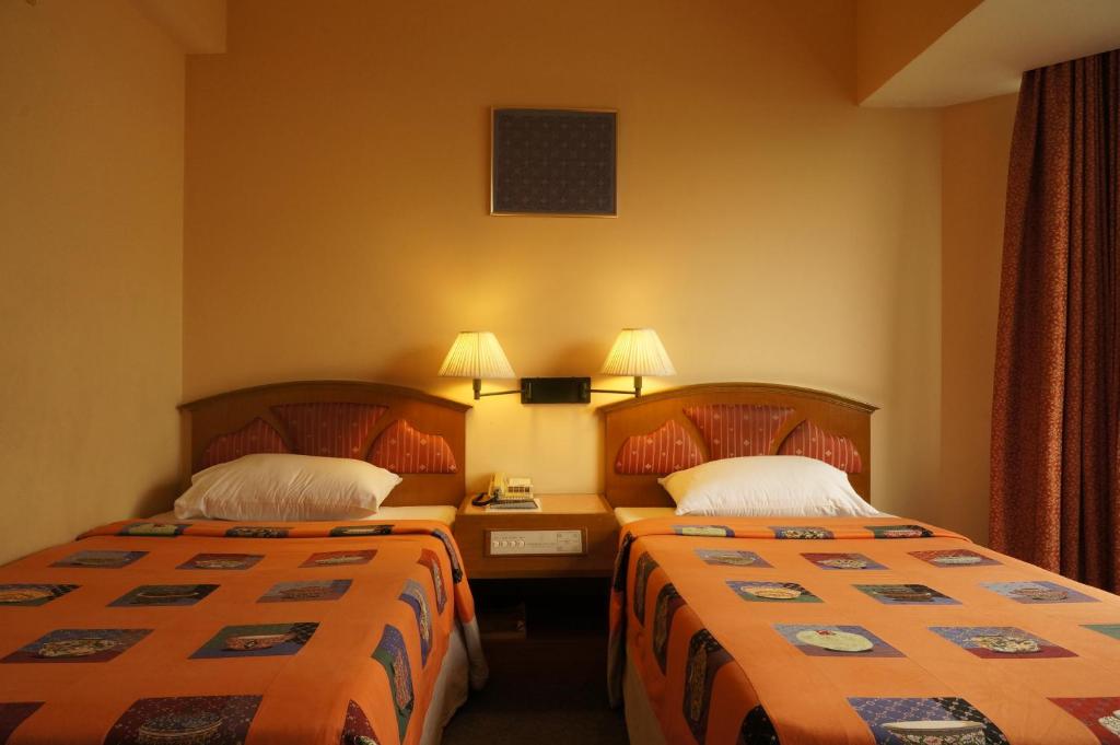 een hotelkamer met twee bedden in een kamer bij Bangkok City Inn in Bangkok