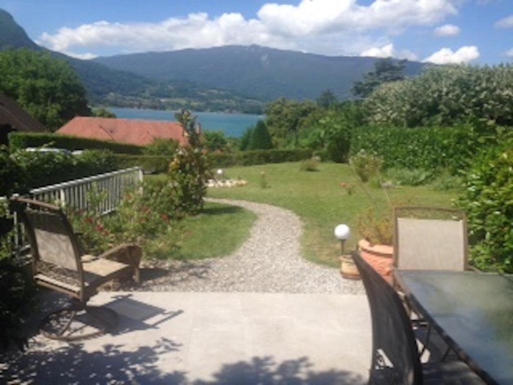 a patio with a view of a lake and mountains at Maison du Lac le Studio in Talloires